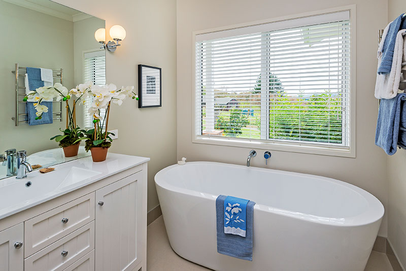 Traditional style vanity with free standing bath and blue accents in award winning home