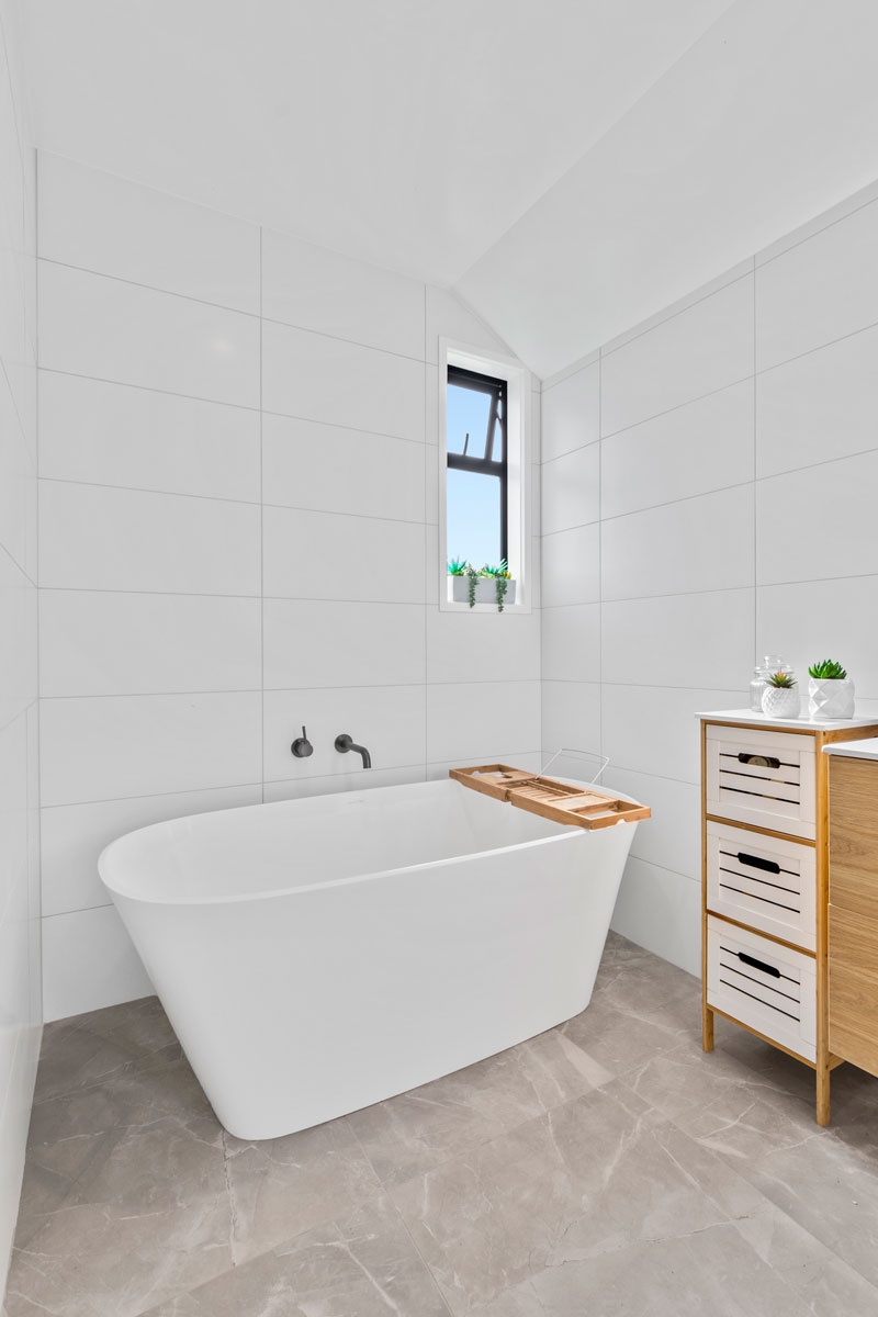 Gorgeous light bathroom grey floor tiles and large freestanding bath from Plumbing World 