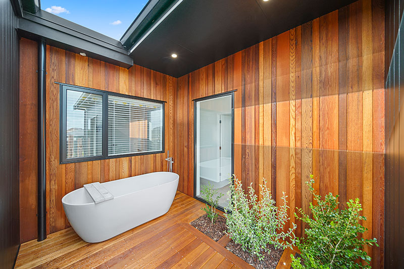 Stunning outdoor bath on deck at Paerata Rise Showhome. Cedar cladding and in deck planted shrubs