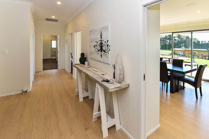 natural styled entrance and hallway. white and timber tones with trestle style hall table and wooden flooring
