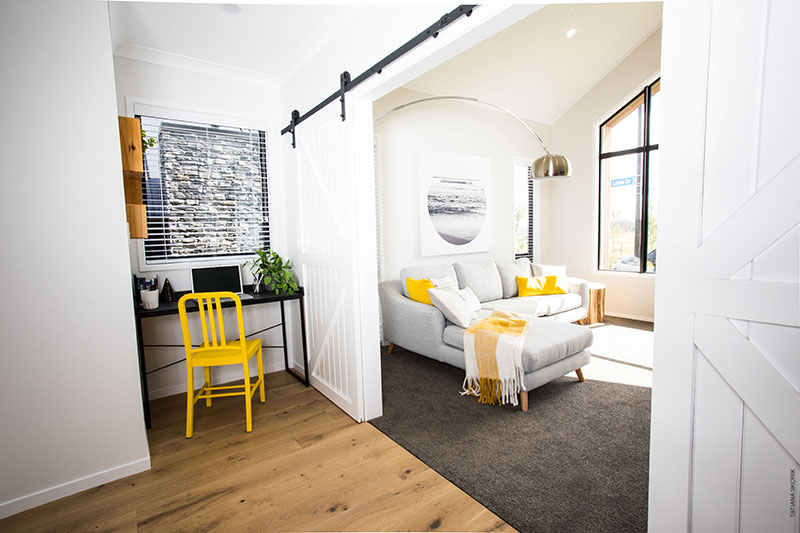 Lounge and study nook at Precision Homes Paerata Rise Showhome with grey yellow and black accents plus barn door
