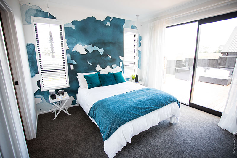 Fresh white and turquoise master bedroom with ink blot mural wallpaper, hanging lights and white blinds