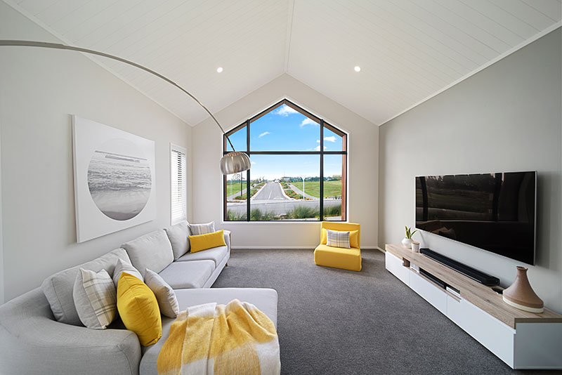 Yellow and grey lounge with lovely high arched window and raking ceilings with arco designer lamp