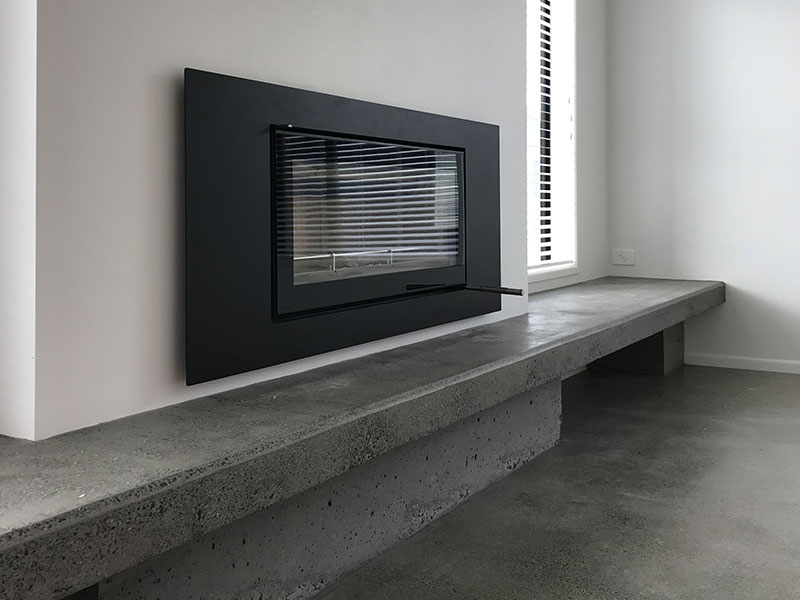 beautiful simple fireplace with concrete hearth seat bench with storage underneath and concrete floor