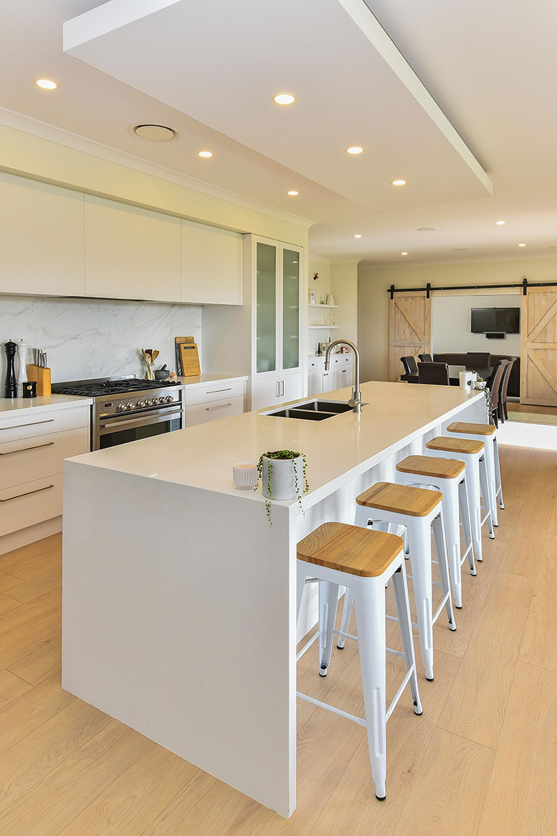 Light scandinavian style kitchen with white cabinets & benchtop, marble splashback & Timber floor.