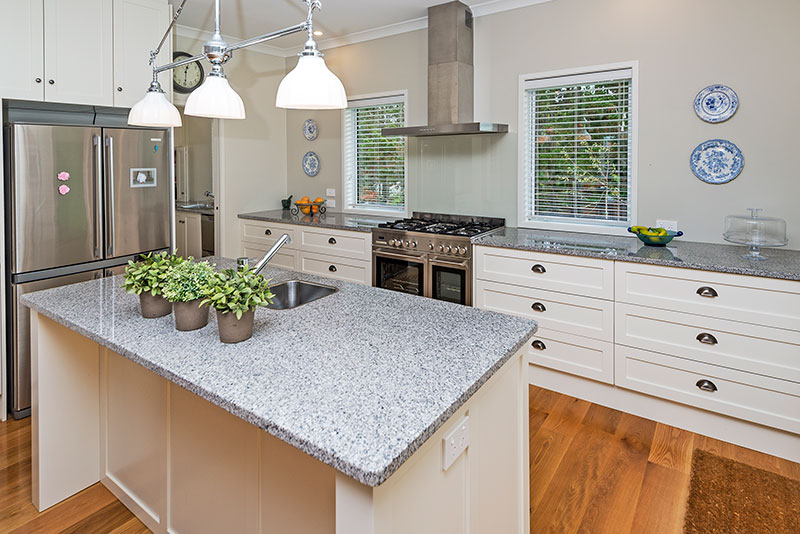 Beautiful traditional kitchen cabinets, granite benchtop and feature lights in award winning home