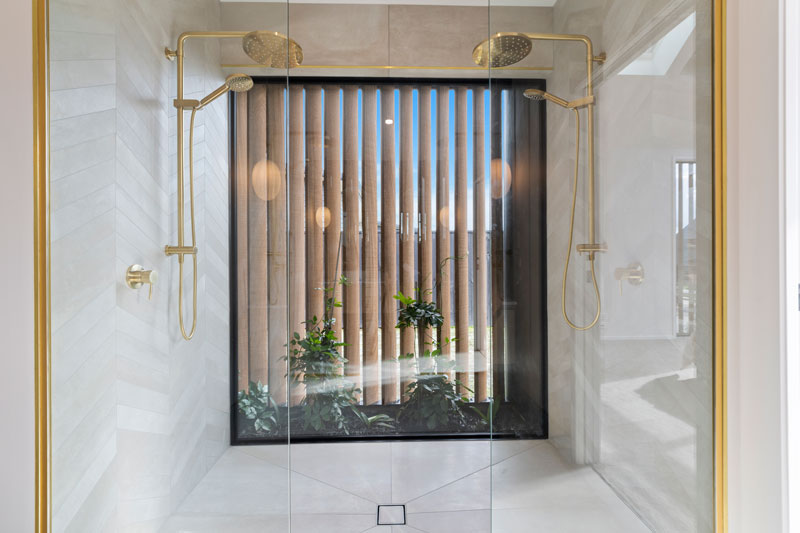 Luxurious Ensuite Bathroom with double shower with full size window and brass fittings