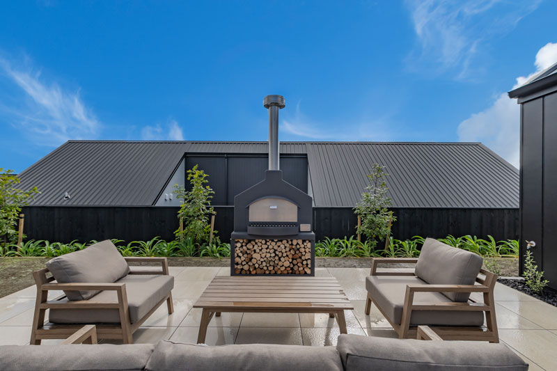 Paerata Rise Showhome back deck with BBQ's and More Bakewell wood burner BBQ and couch