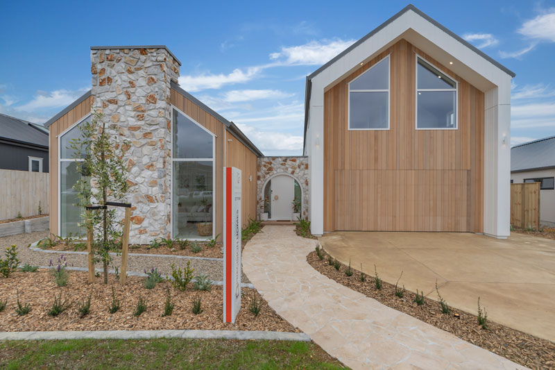 Gorgeous mediterranean inspired home with irregular stone vintage white chimmney, arched front door, Precision Homes showhome