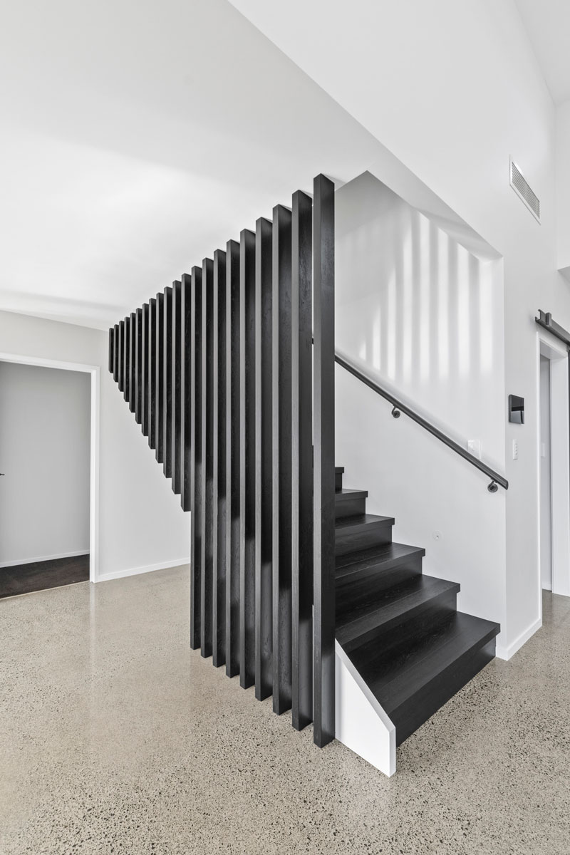 stunning stair balustrade rails, black and white, polished concrete floors in designer home