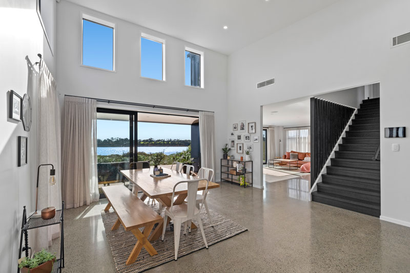 open plan living/dining area, black balustrade rails and steps, polished concrete floors in designer home