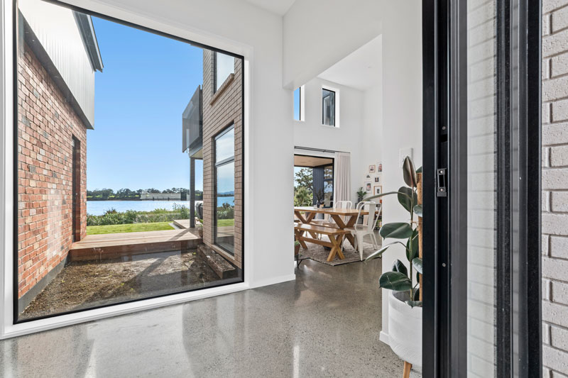 stunning large open window in entrance, polished concrete floors in designer home
