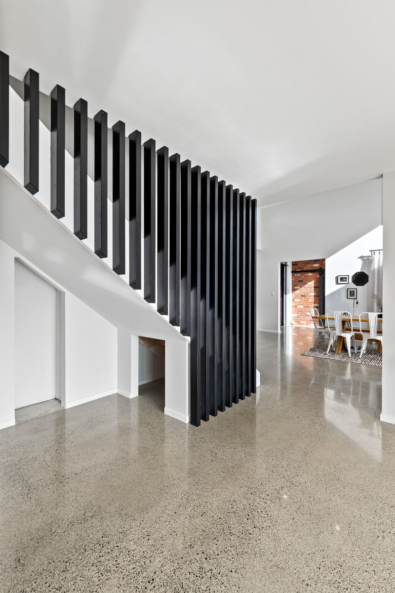 stunning stair balustrade rails, black and white, polished concrete floors in designer home