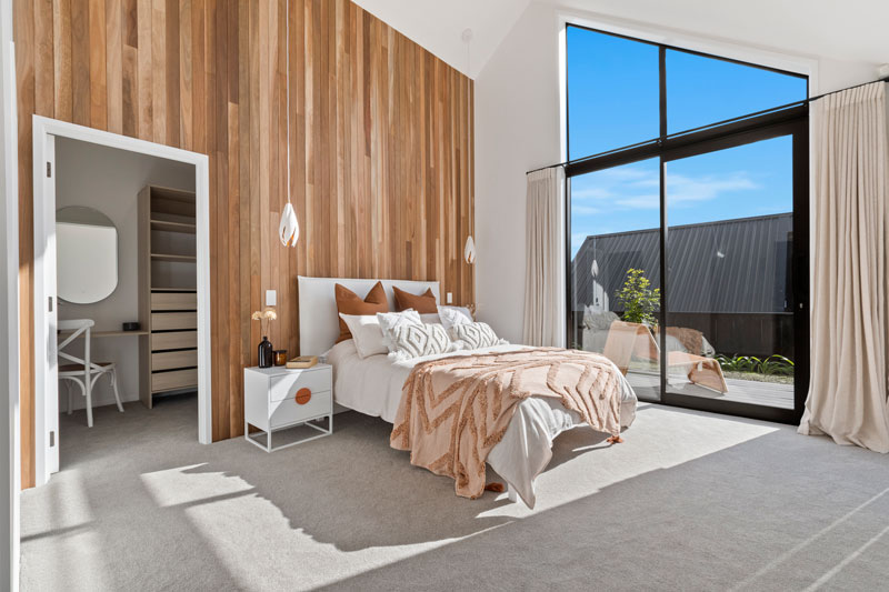 Large spacious master bedroom with cathedral ceilings and timber feature wall