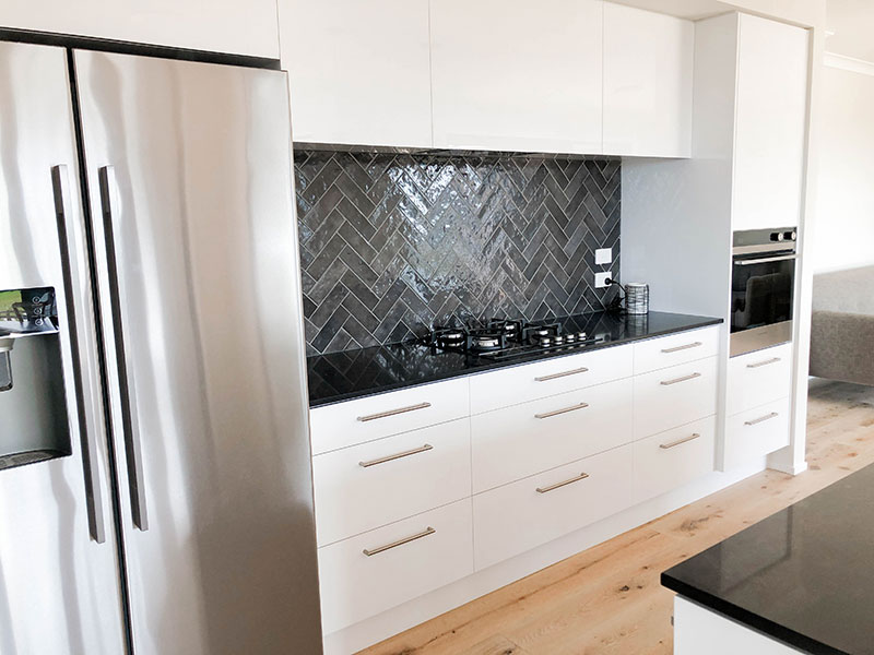 Black and white kitchen with French Oak timber floor and charcoal artisan splashback tiles