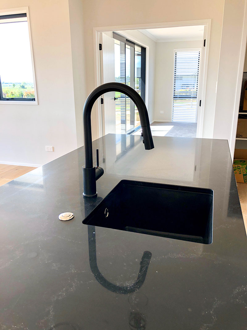Black marble benchtop with black sink and black tap