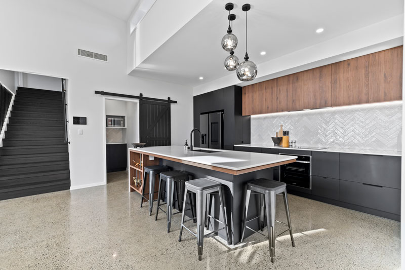 Gorgeous kitchen with black cabintry marble benchtop, and timber accents in designer home in Glenbrook